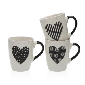 Set de tres tazas color crema con asas negras y diferentes diseños de corazones en negro.